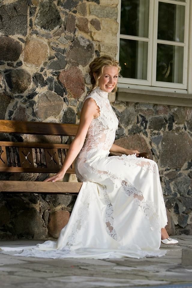 Bride seated in a lace gown with a high neckline