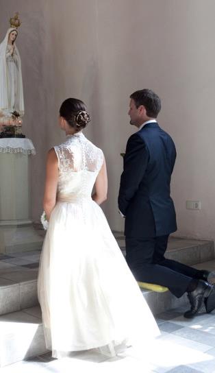 Bride and groom during their wedding ceremony, with the gown shown from behind