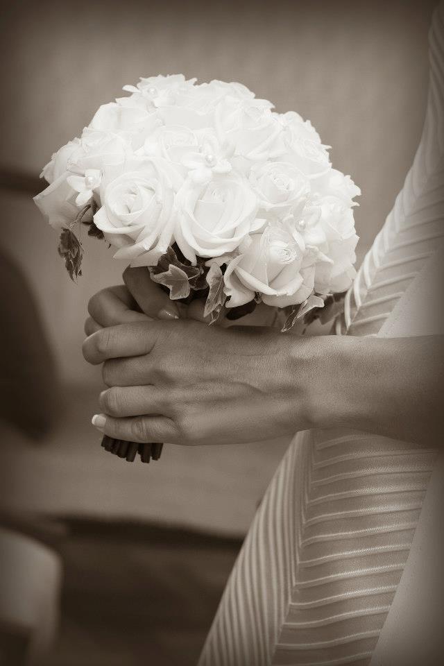 Close view of the bride's bouquet and pleated gown