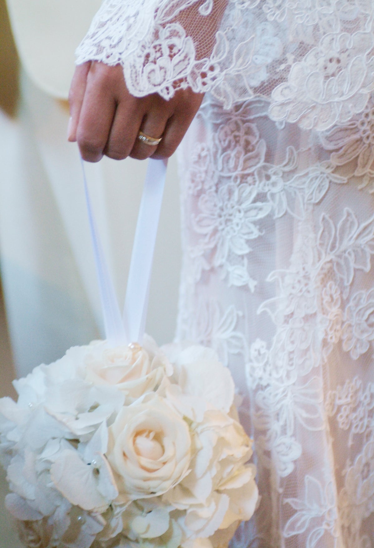 Close view of a lace sleeve and the bride's hand