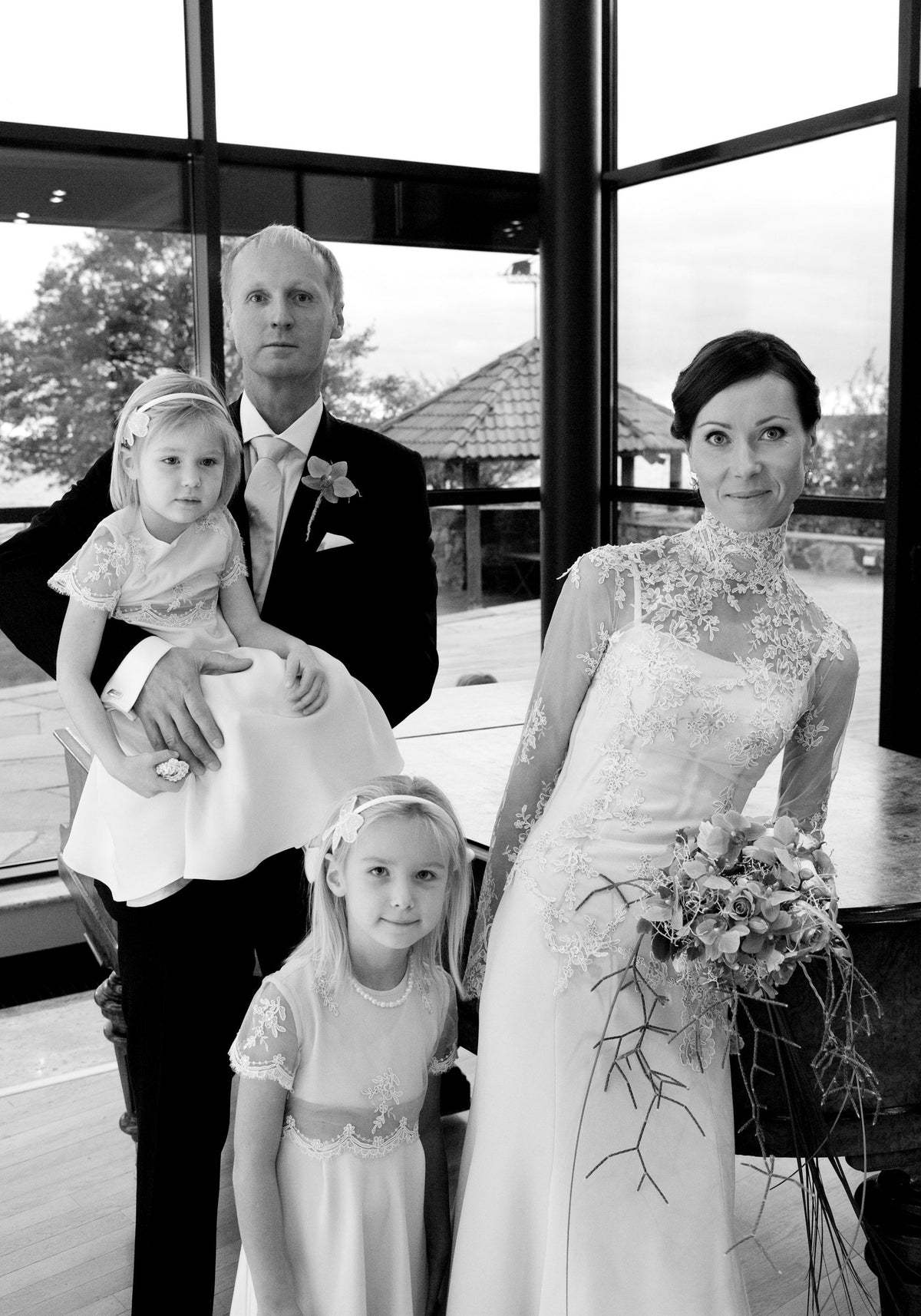 Bride in a high-neck lace gown with a fitted bodice in a family wedding portrait