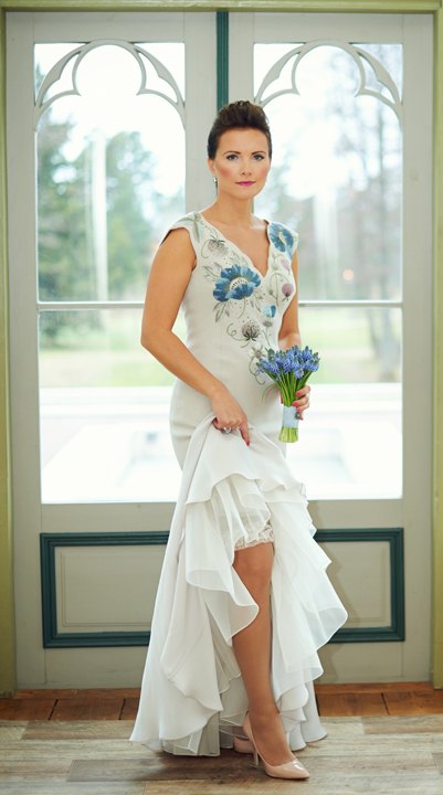 Bride in a sleeveless gown with an embroidered bodice and asymmetrical layered skirt